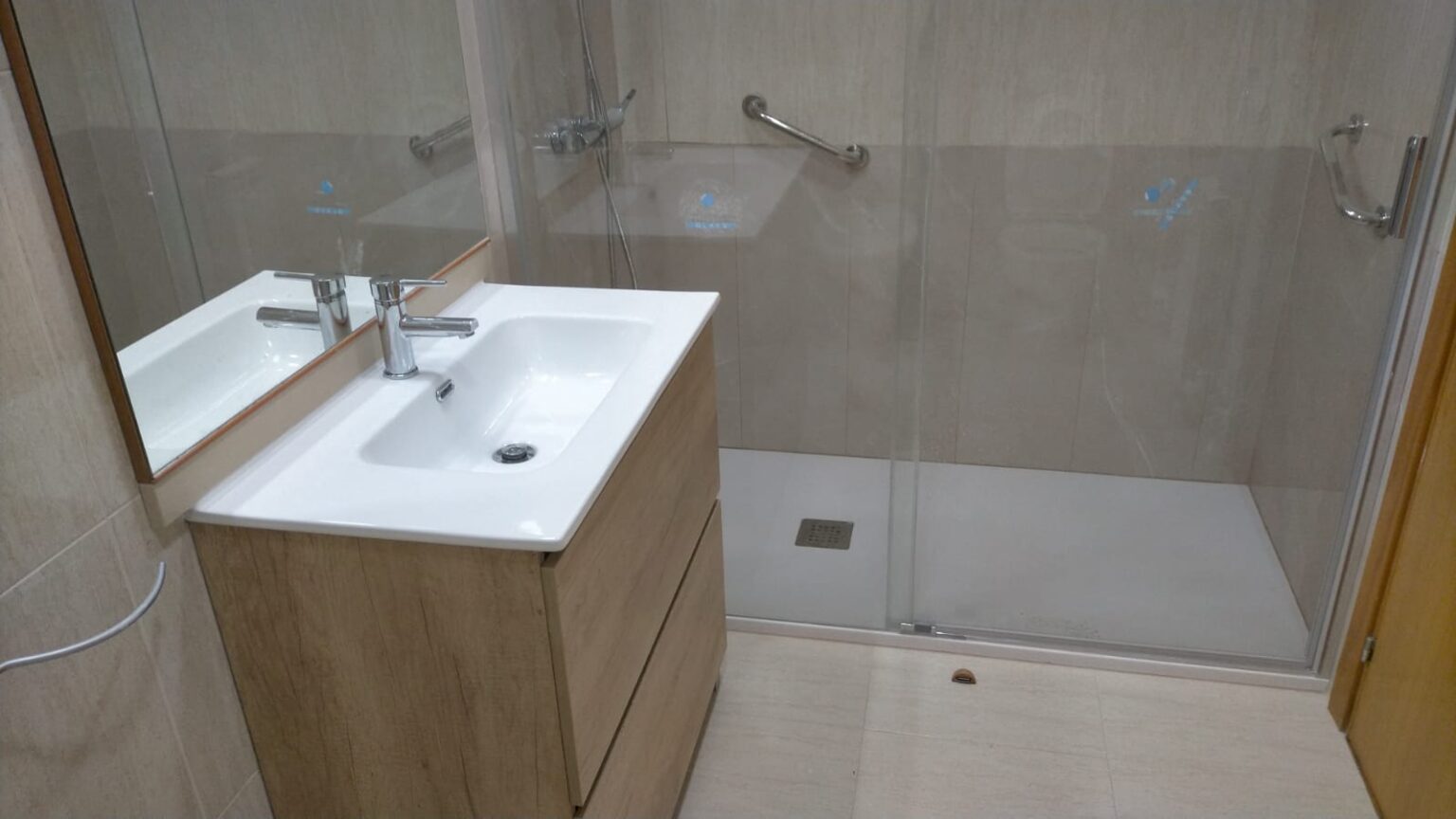Baño reformado en Santa Coloma de Gramenet con azulejos claros y acabado moderno.