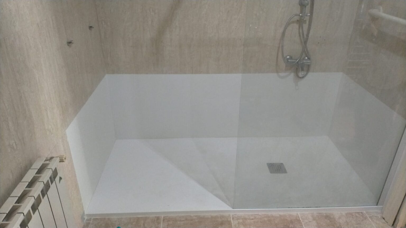 Alicatado de paredes en un baño durante la fase intermedia de la reforma.
